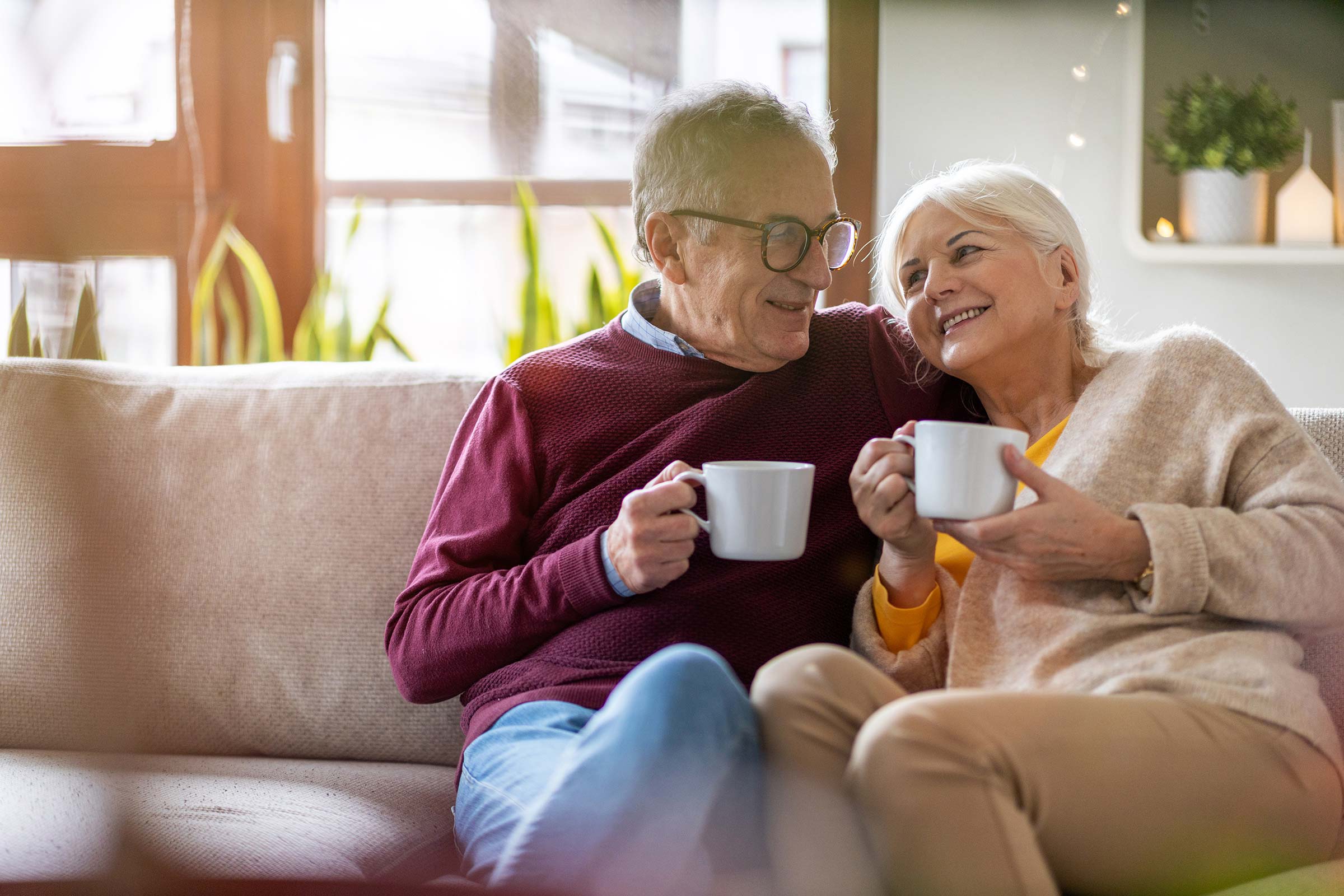 Senior couple sitting on a sofa and drinking coffee