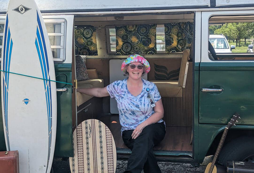 Melissa Straube sitting in a VW van smiling for the camera.