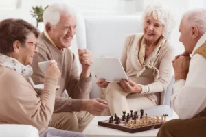 Group of four playing chess and talking