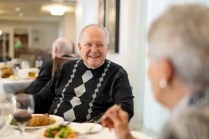 A man eating with another person in the foreground