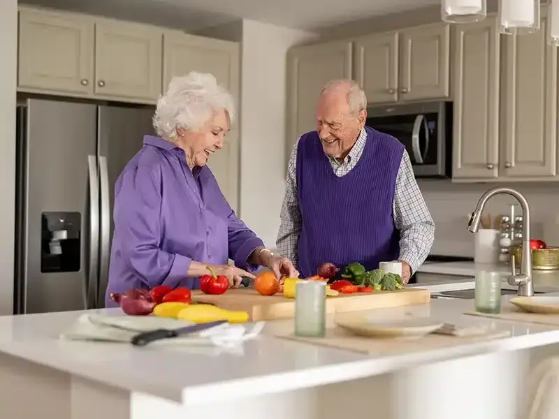 a resident couple cooking in their kitchen